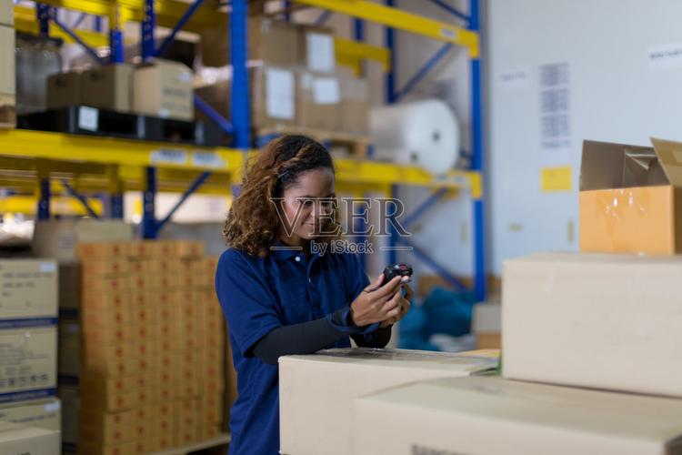 女工在工業工廠倉庫使用條碼機檢查產品或托盤上的包裹貨物檢驗質量